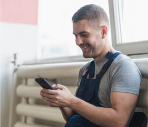 A man smiles on his phone after replacing a water purification system in Overland Park.