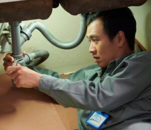 An emergency plumber in Jackson County works on a sink.