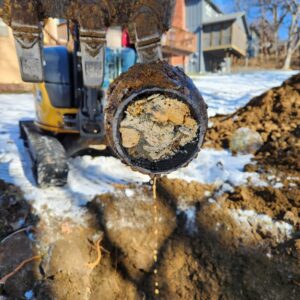 Our team members remove a sewer line filled with mud and dirt during sewer repair in Johnson County.