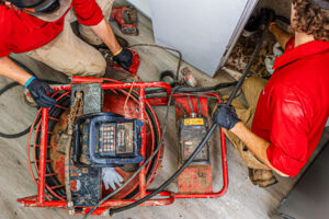 An overhead of two of our team members performing drain cleaning in Olathe.