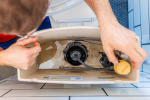 An emergency plumber in Jackson County fixes a damaged toilet.