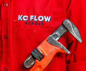 An emergency plumber in Johnson County carries a wrench against his chest.